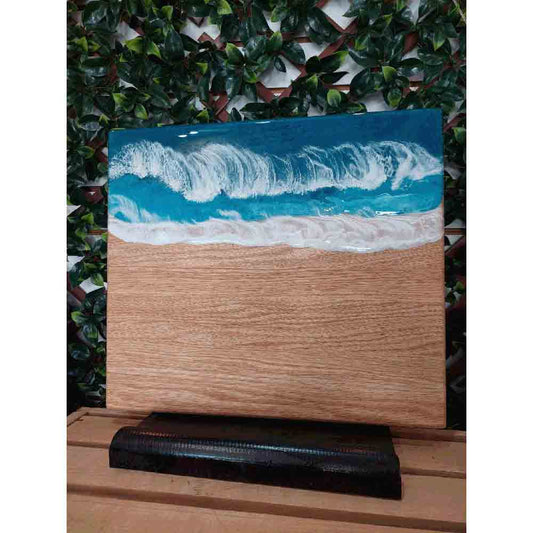 Oak cutting board with resin painting of ocean and waves.