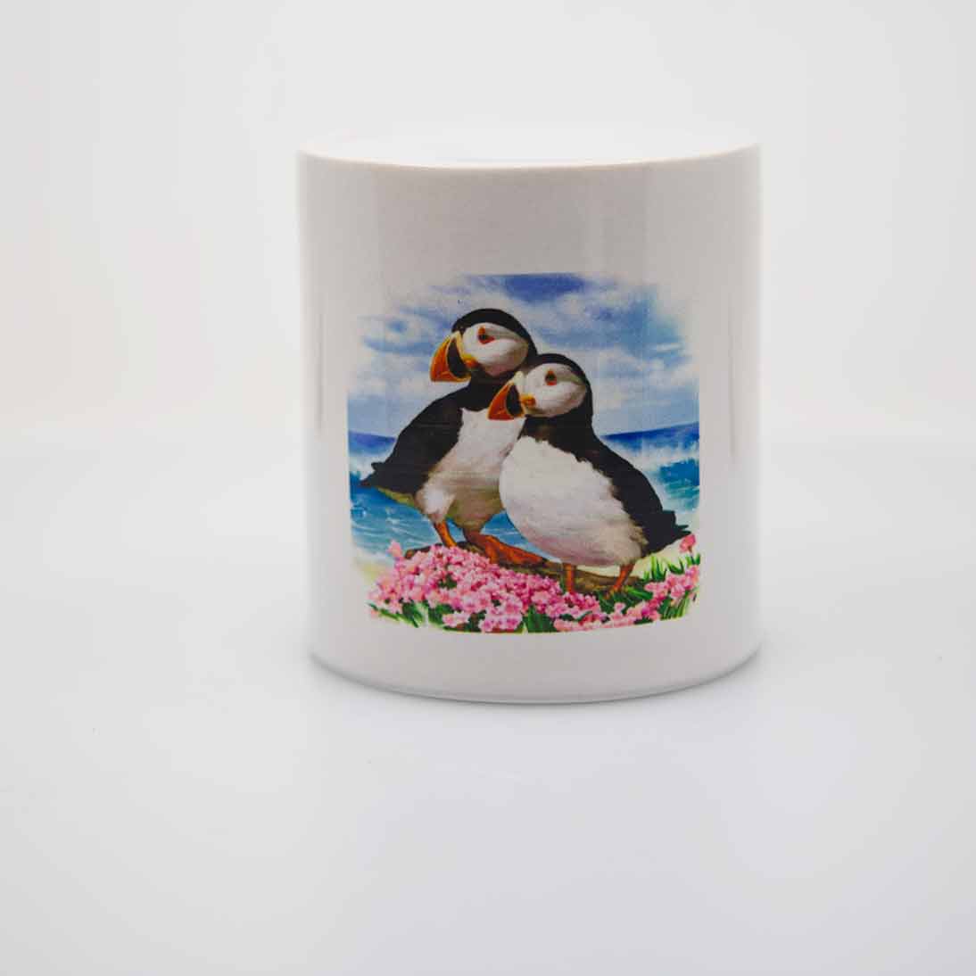 A round ceramic "piggy bank" or money jar with a pair of puffins looking off into the distance.