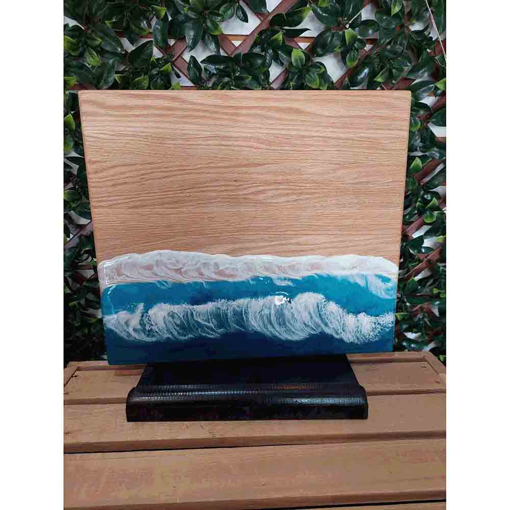 Ocean cutting board with resin ocean and wave painting.