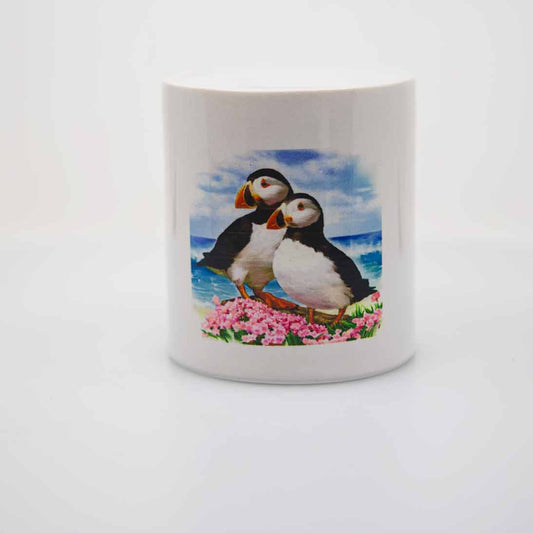 A round ceramic "piggy bank" or money jar with a pair of puffins looking off into the distance. 